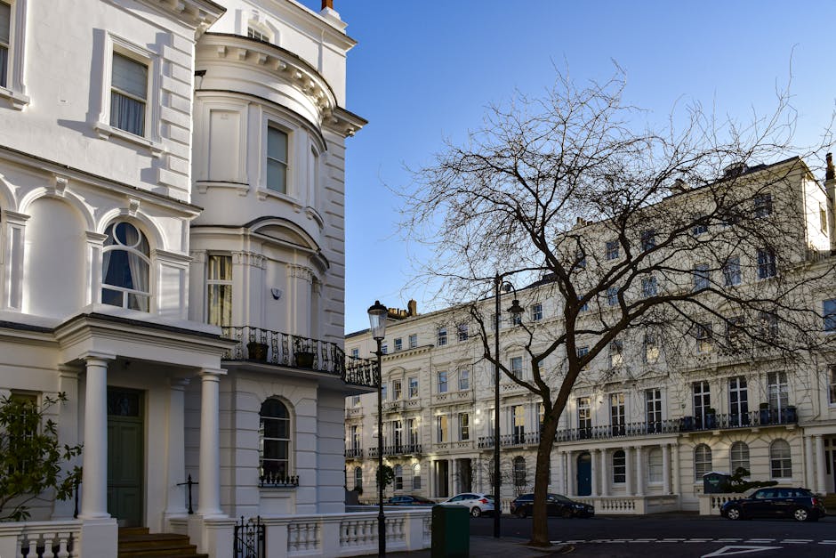 Exterior view of a row of white Victorian-style terraced houses on Clapham Common, with detailed architectural features including rounded bay windows, decorative cornices, and iron balcony railings. T